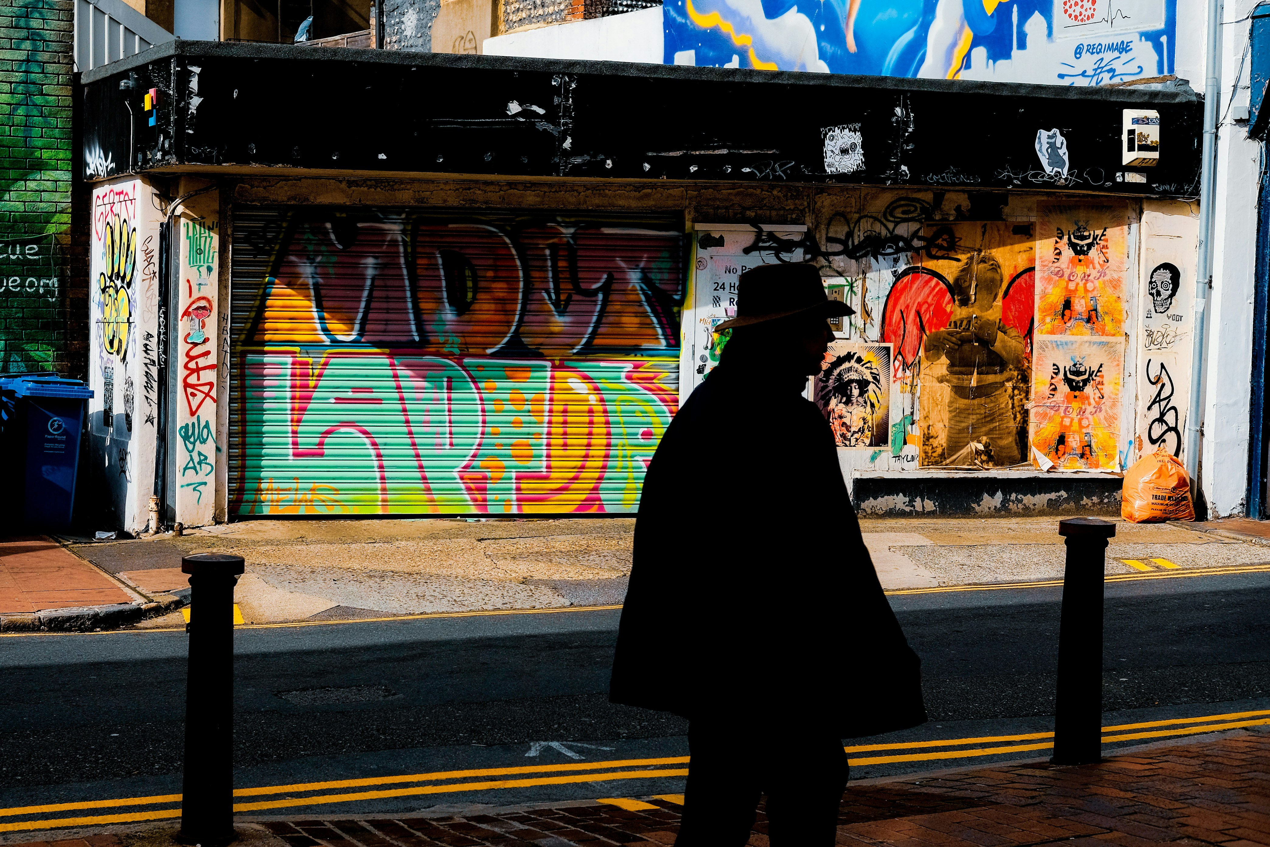 person in black coat walking on sidewalk during daytime